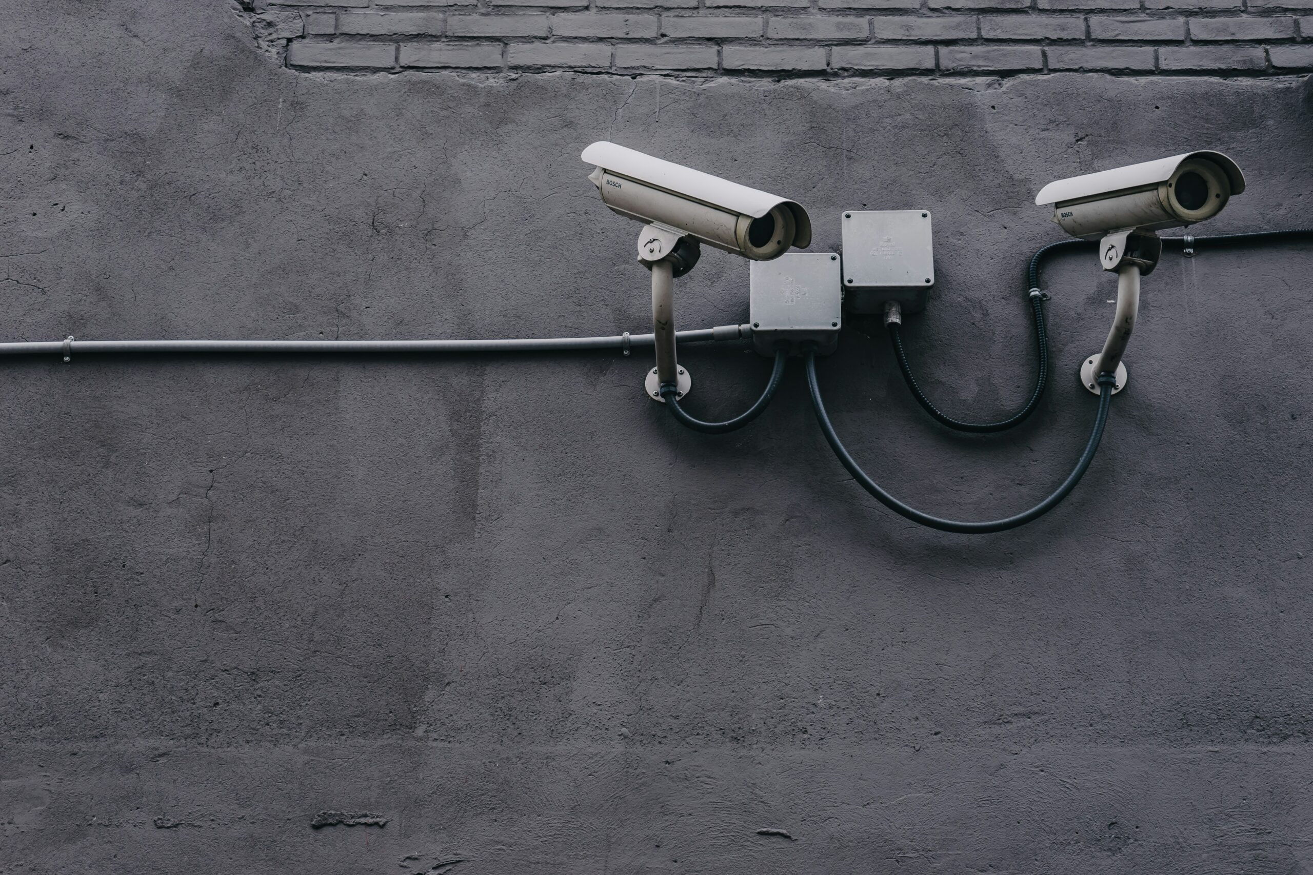 Cameras de vigilância em uma parede de concreto.